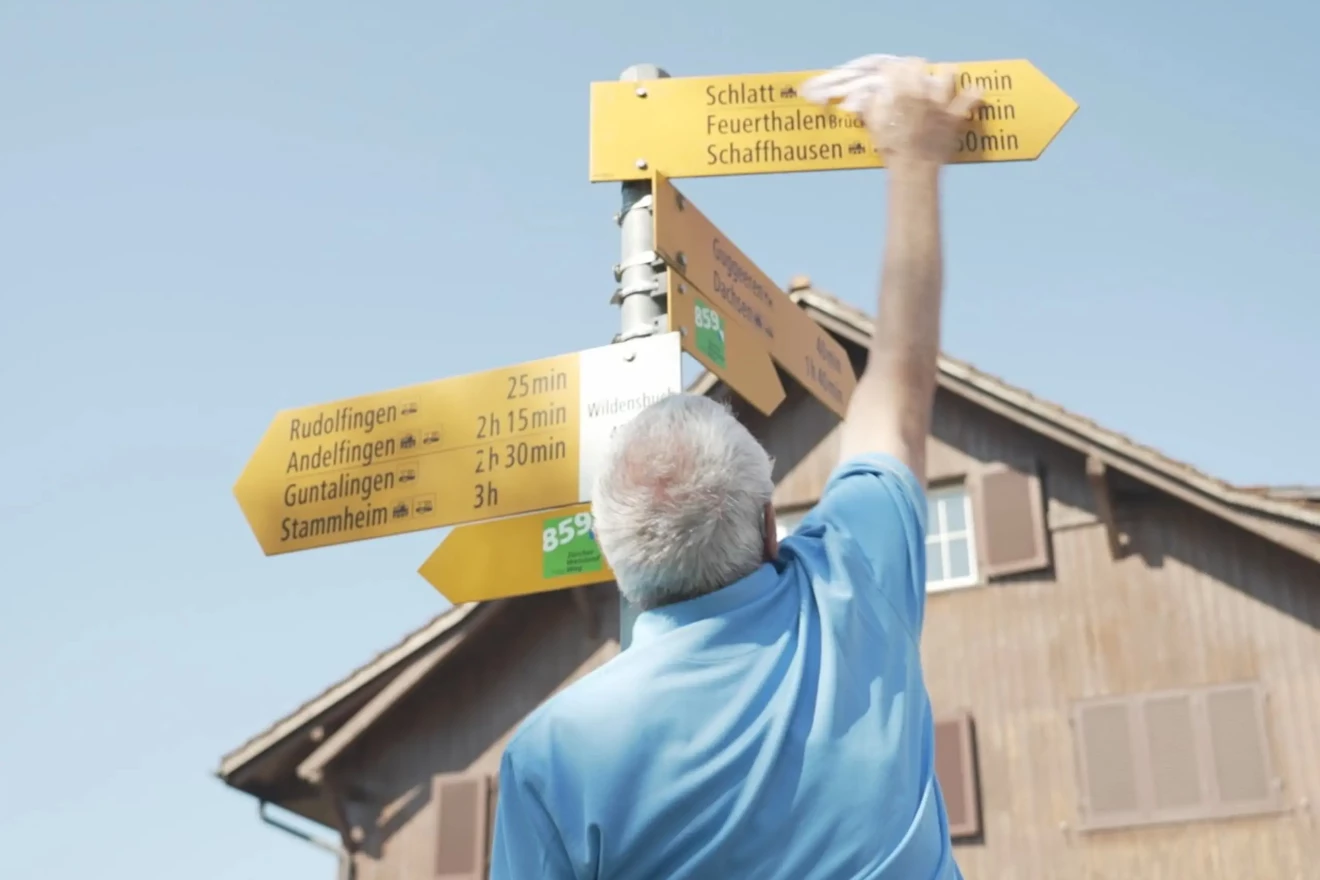 Ein Freiwilliger putzt die Beschriftungen von Wanderwegen.