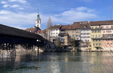 Zu sehen ist eine Holzbr&uuml;cke, welche &uuml;ber die Aare zu einem Altstadtteil der Stadt Olten f&uuml;hrt.